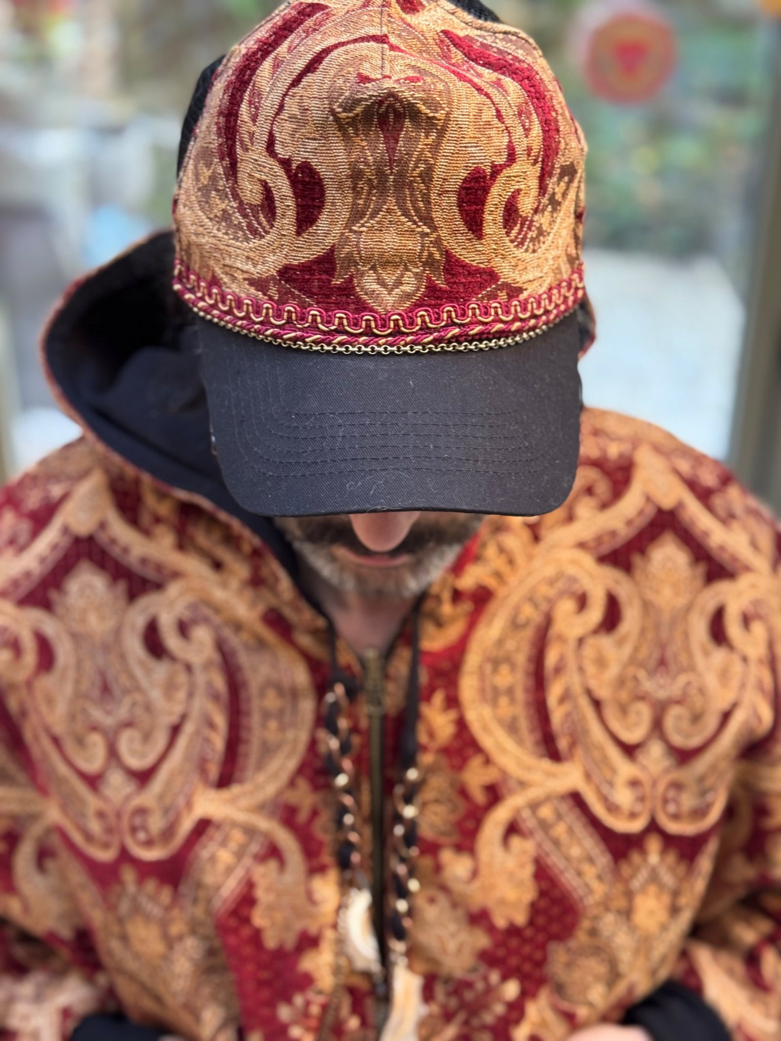 Close-up of a red and gold chenille jacquard hoodie and matching baseball cap